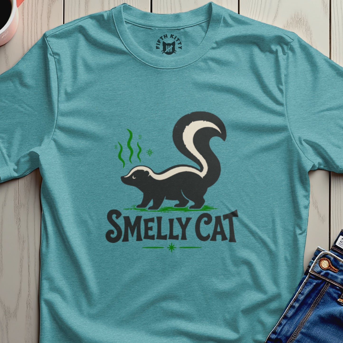 Teal t-shirt with a skunk graphic and the text "SMELLY CAT".