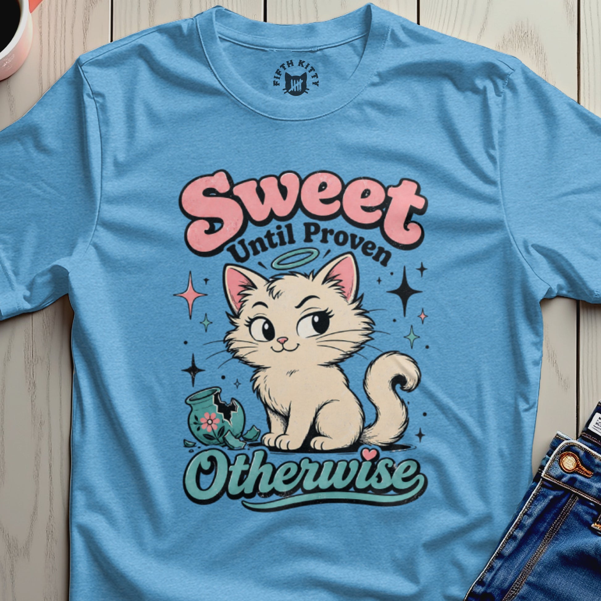 Blue t-shirt with "Sweet Until Proven Otherwise" text and cartoon cat with broken vase.