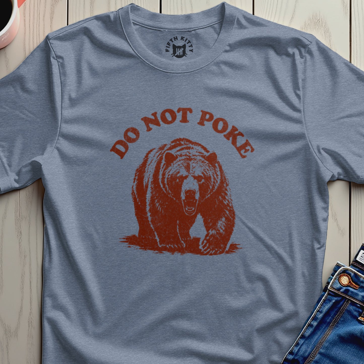 Bear graphic with "DO NOT POKE" text on a heather blue t-shirt.