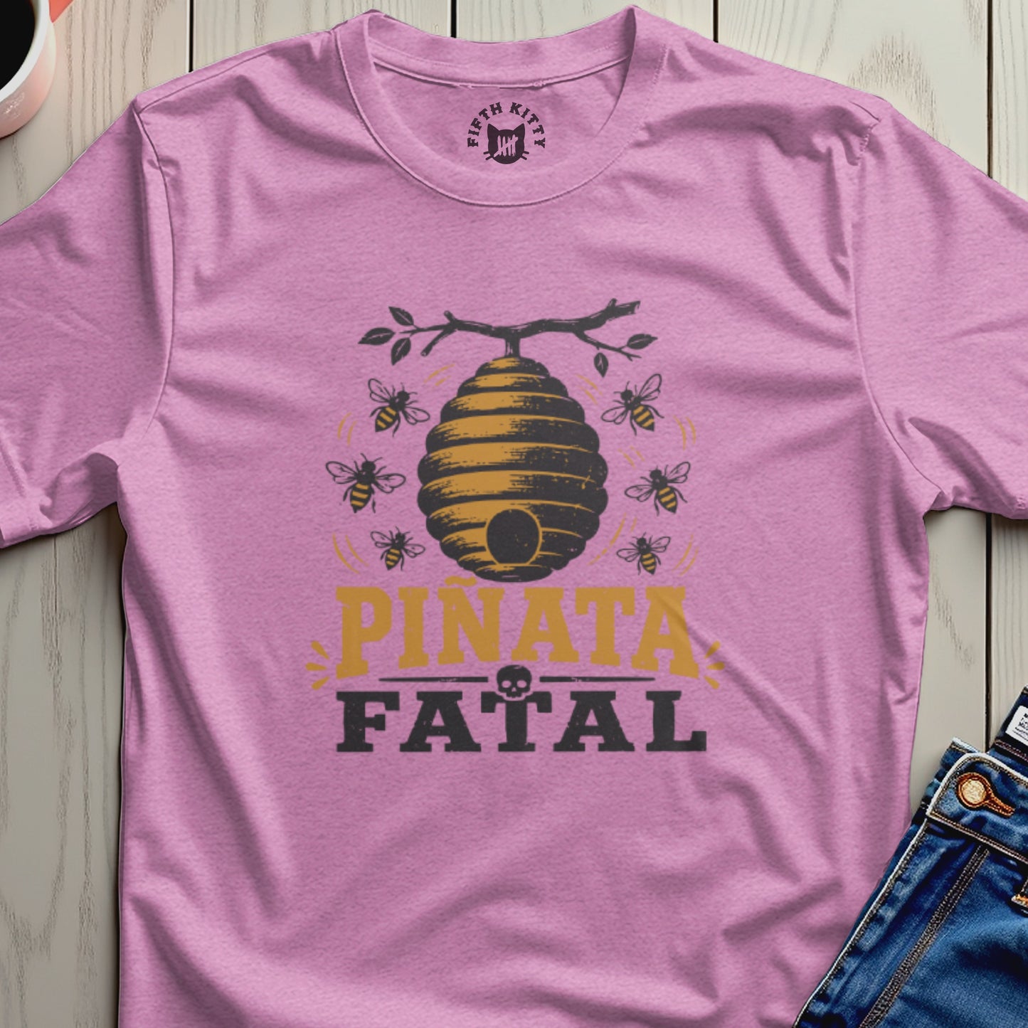 Pink t-shirt with a beehive graphic and text "PIÑATA FATAL".