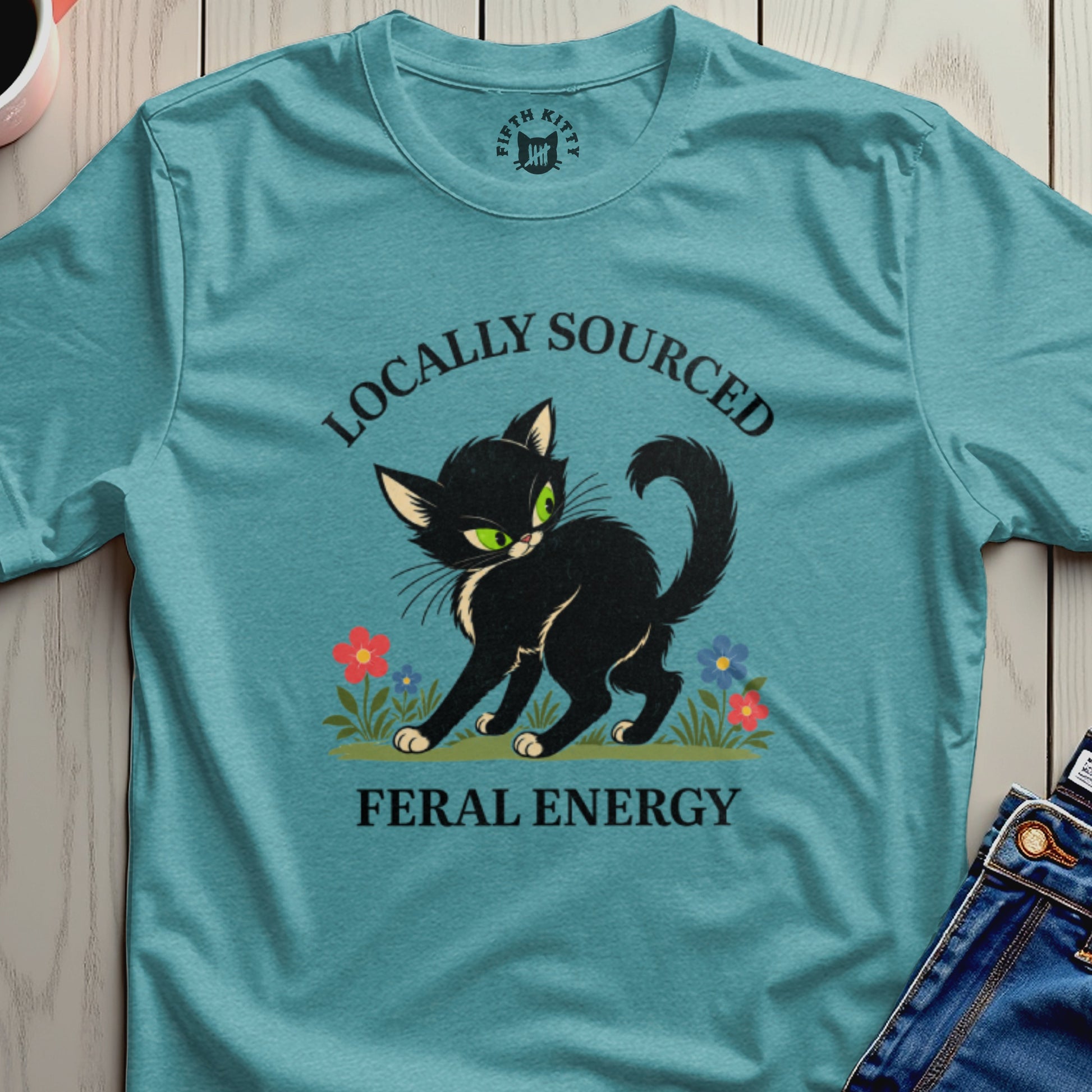 Black cat with green eyes among flowers, text reads "Locally Sourced Feral Energy."