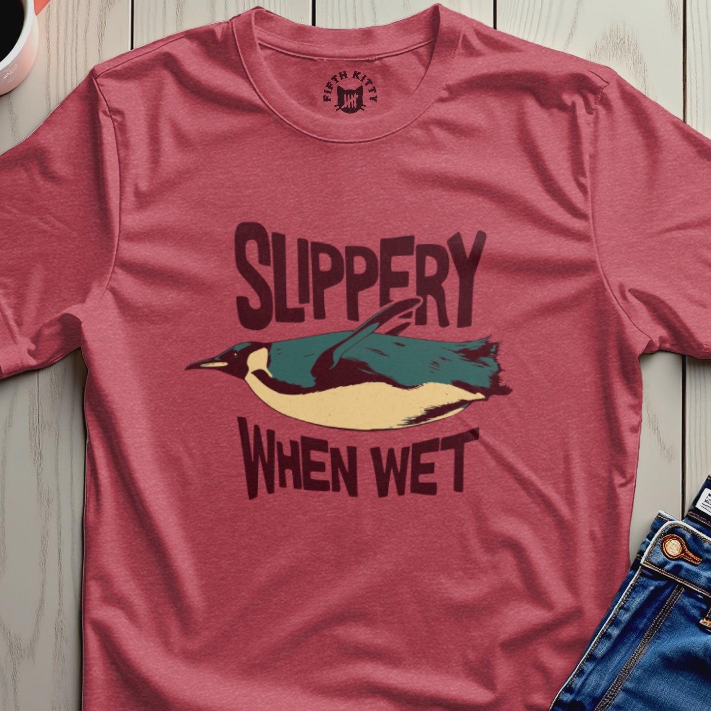 Red t-shirt with graphic of a penguin and text "Slippery When Wet".