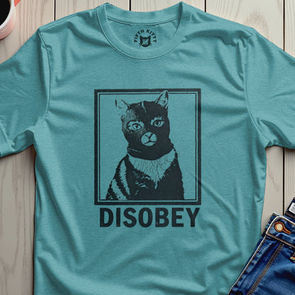Black cat in a ski mask with "DISOBEY" text, printed on a teal t-shirt.
