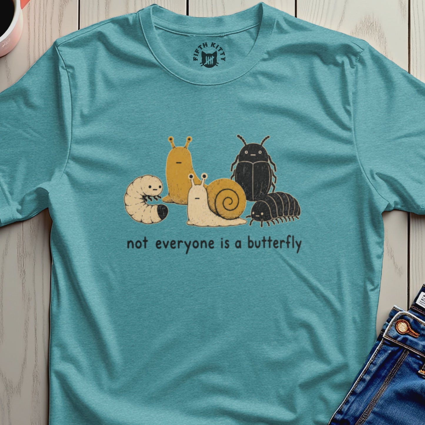 Teal t-shirt featuring cartoon insects and the text "not everyone is a butterfly".