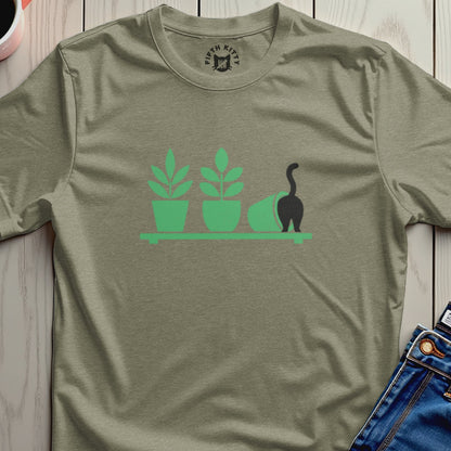 Green t-shirt with silhouette of plants and a black cat knocked over a pot.