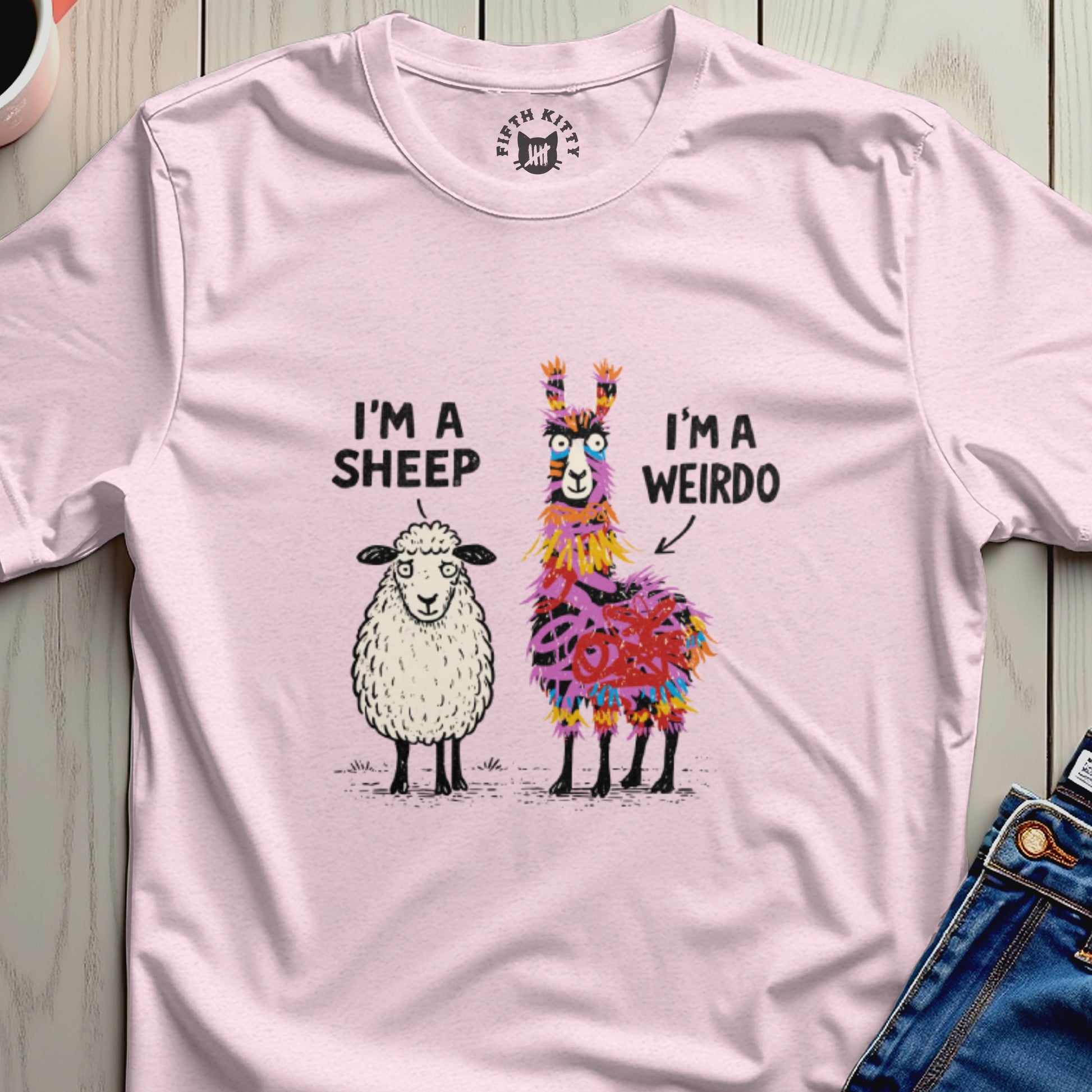 Pink t-shirt with illustrations of a sheep and a colorful llama, text reads "I'M A SHEEP I'M A WEIRDO".