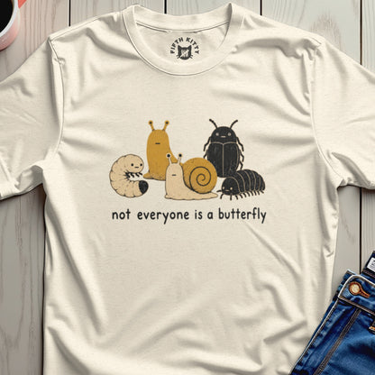 Cream t-shirt with cartoon insects and text, "not everyone is a butterfly."