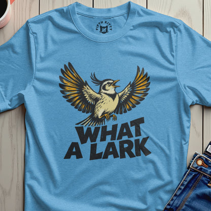 Blue t-shirt with "WHAT A LARK" and a bird with spread wings.