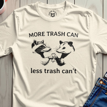 Cream t-shirt with raccoons and opossums giving a fist bump, text reads "MORE TRASH CAN less trash can't".