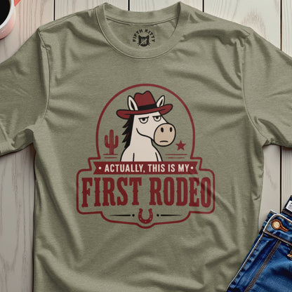 Olive t-shirt with horse wearing cowboy hat saying "Actually, This Is My First Rodeo."