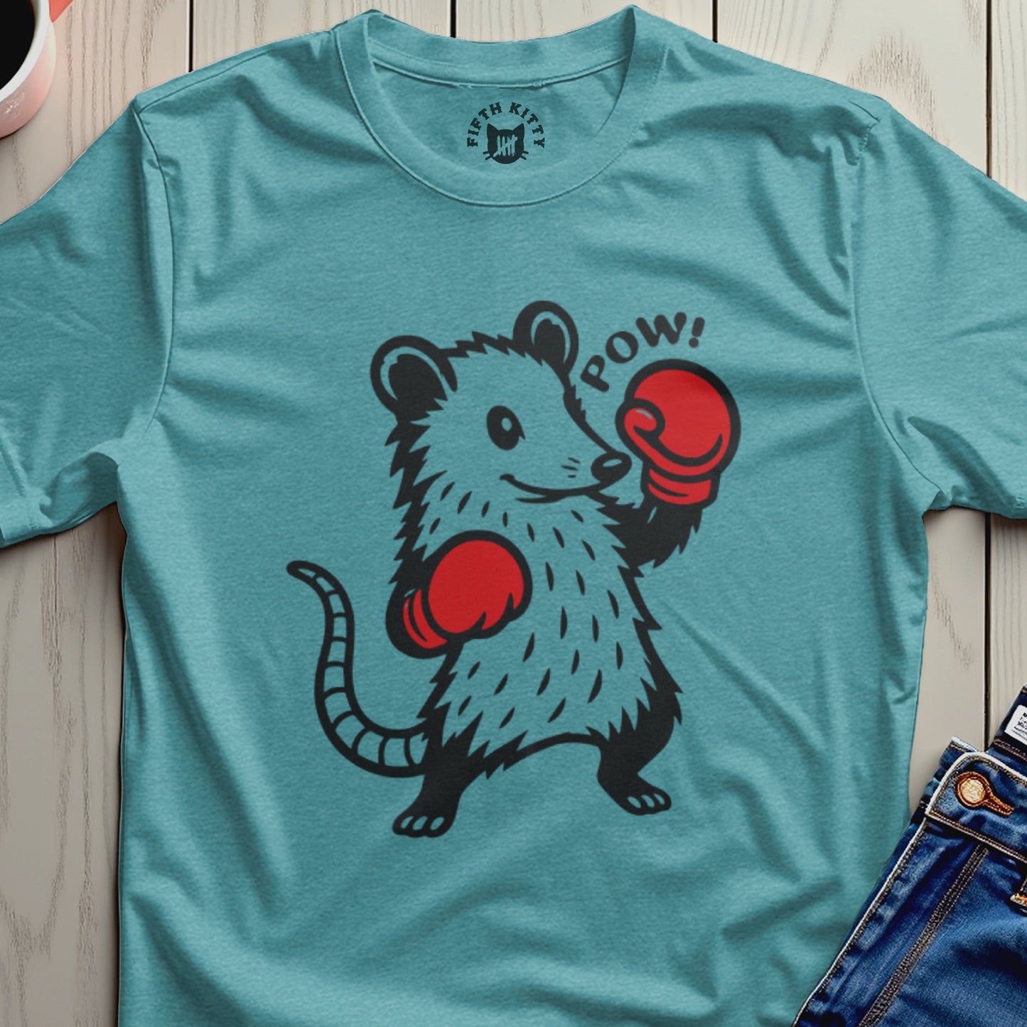 Boxing possum graphic with "POW!" text on a teal t-shirt.