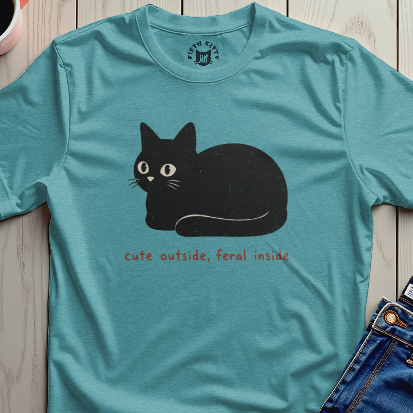 Teal t-shirt with graphic of black cat and text "cute outside, feral inside".