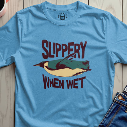 Light blue t-shirt with a penguin graphic and text "SLIPPERY WHEN WET".