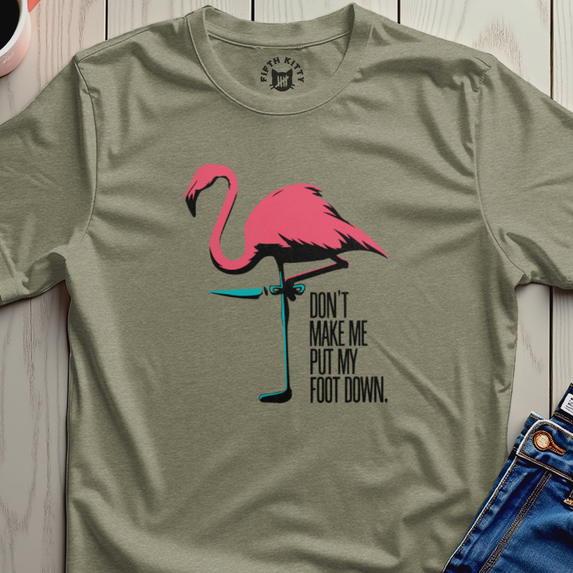 Olive t-shirt with a pink flamingo and the text "DON'T MAKE ME PUT MY FOOT DOWN."