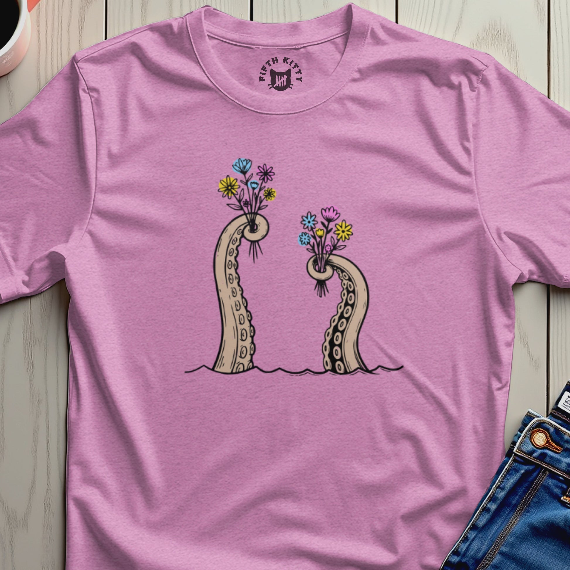 Pink t-shirt with illustration of two octopus tentacles holding bouquets of flowers.