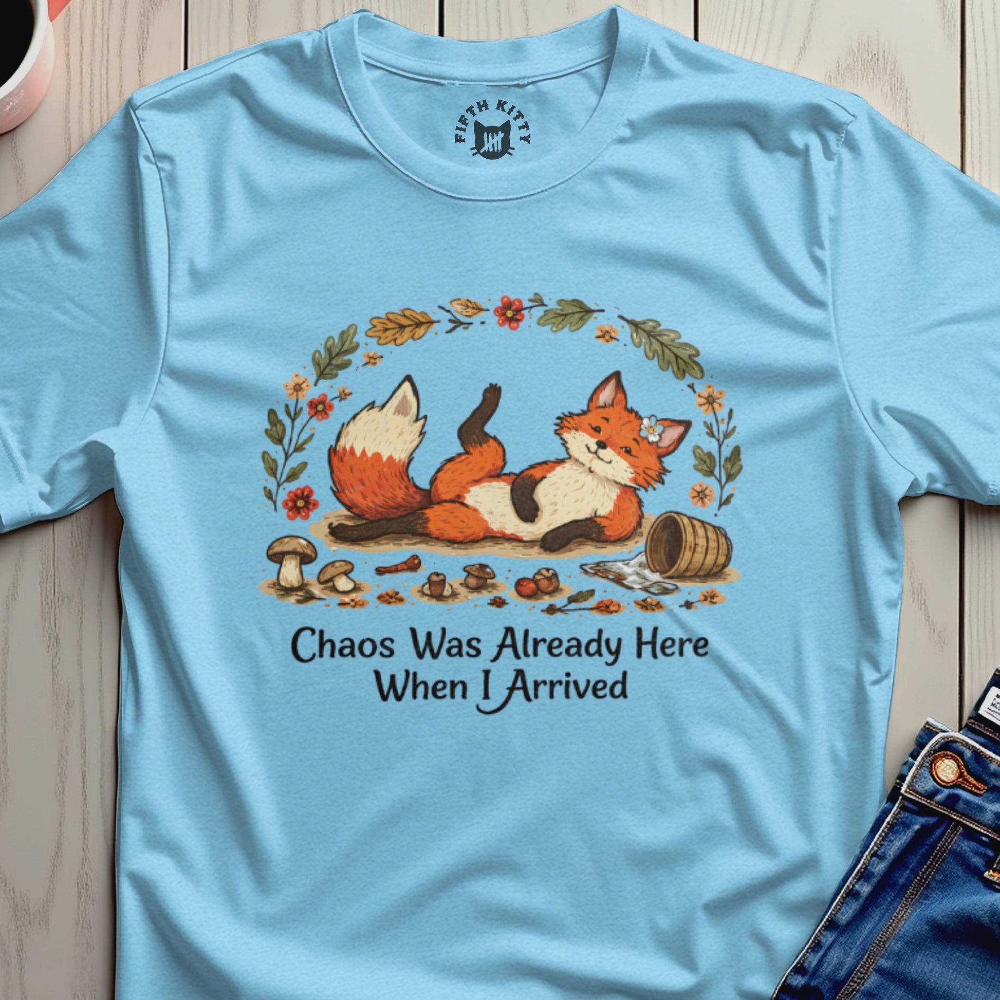 Light blue t-shirt with a playful fox, mushrooms, and text "Chaos Was Already Here When I Arrived".
