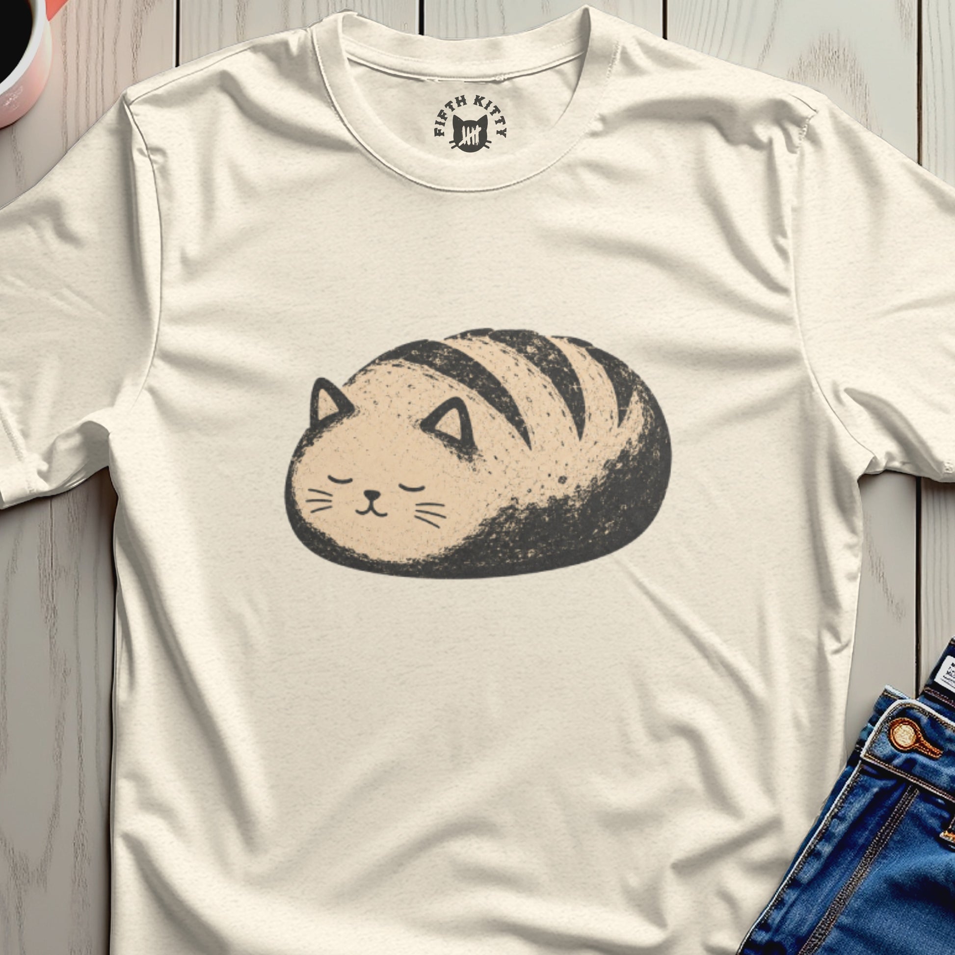 Cream t-shirt with a cute cat-shaped loaf of bread graphic and "Fifth Kitty" logo.