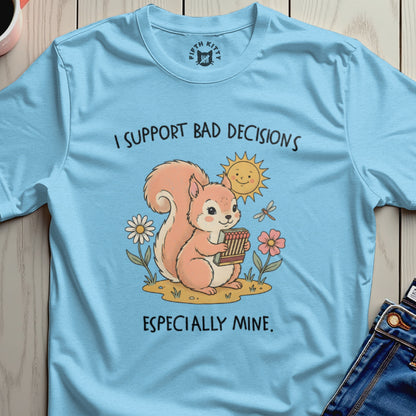 Light blue t-shirt with a cartoon squirrel holding matches, text "I SUPPORT BAD DECISIONS ESPECIALLY MINE."