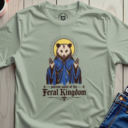 Saintly opossum in blue robe with "patron saint of the feral kingdom" text.