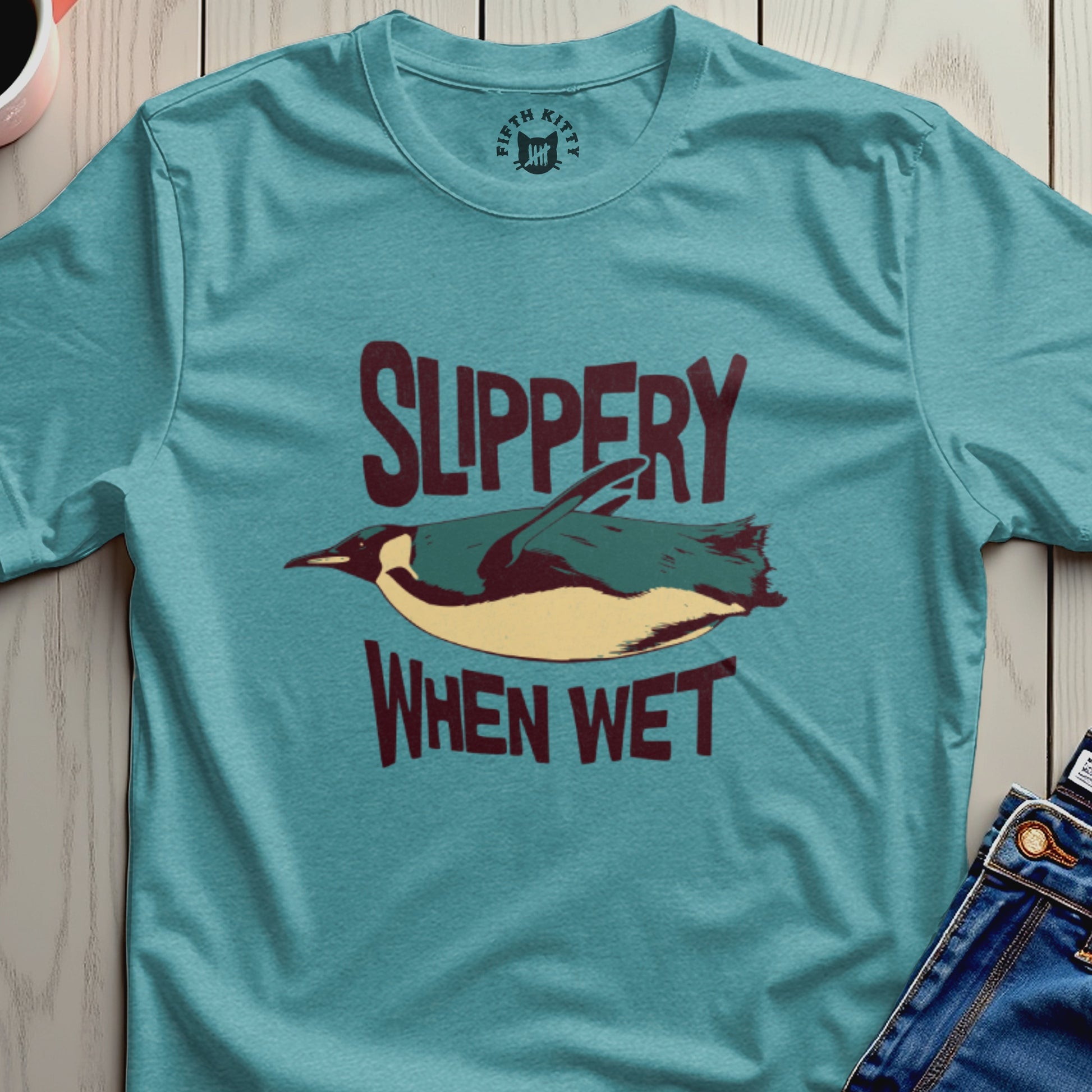 Teal t-shirt with illustration of a penguin and text "SLIPPERY WHEN WET".