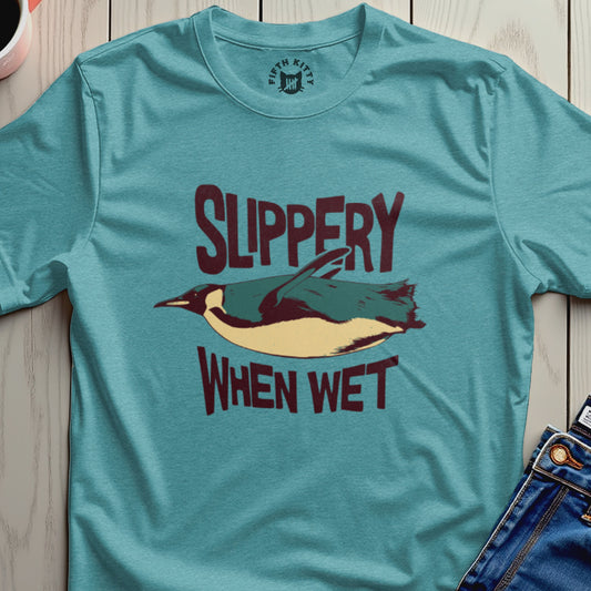 Teal t-shirt with illustration of a penguin and text "SLIPPERY WHEN WET".