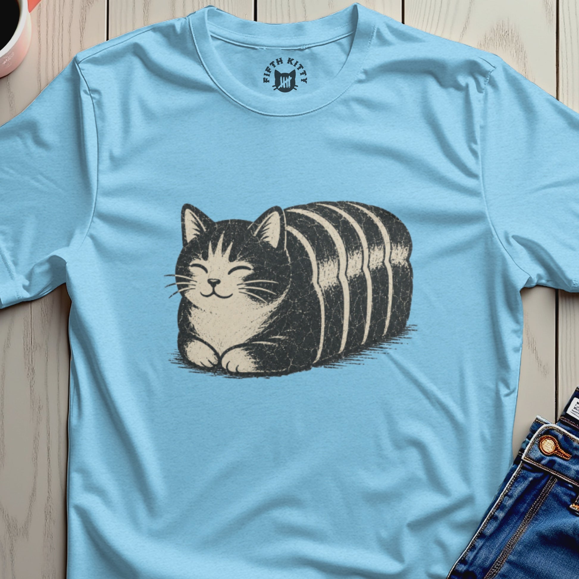 Light blue t-shirt with a black and white striped cat graphic and a circular logo