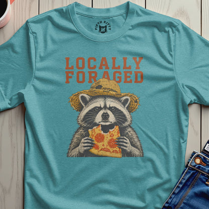 Raccoon wearing a straw hat eats a slice of pizza, "Locally Foraged" text above.