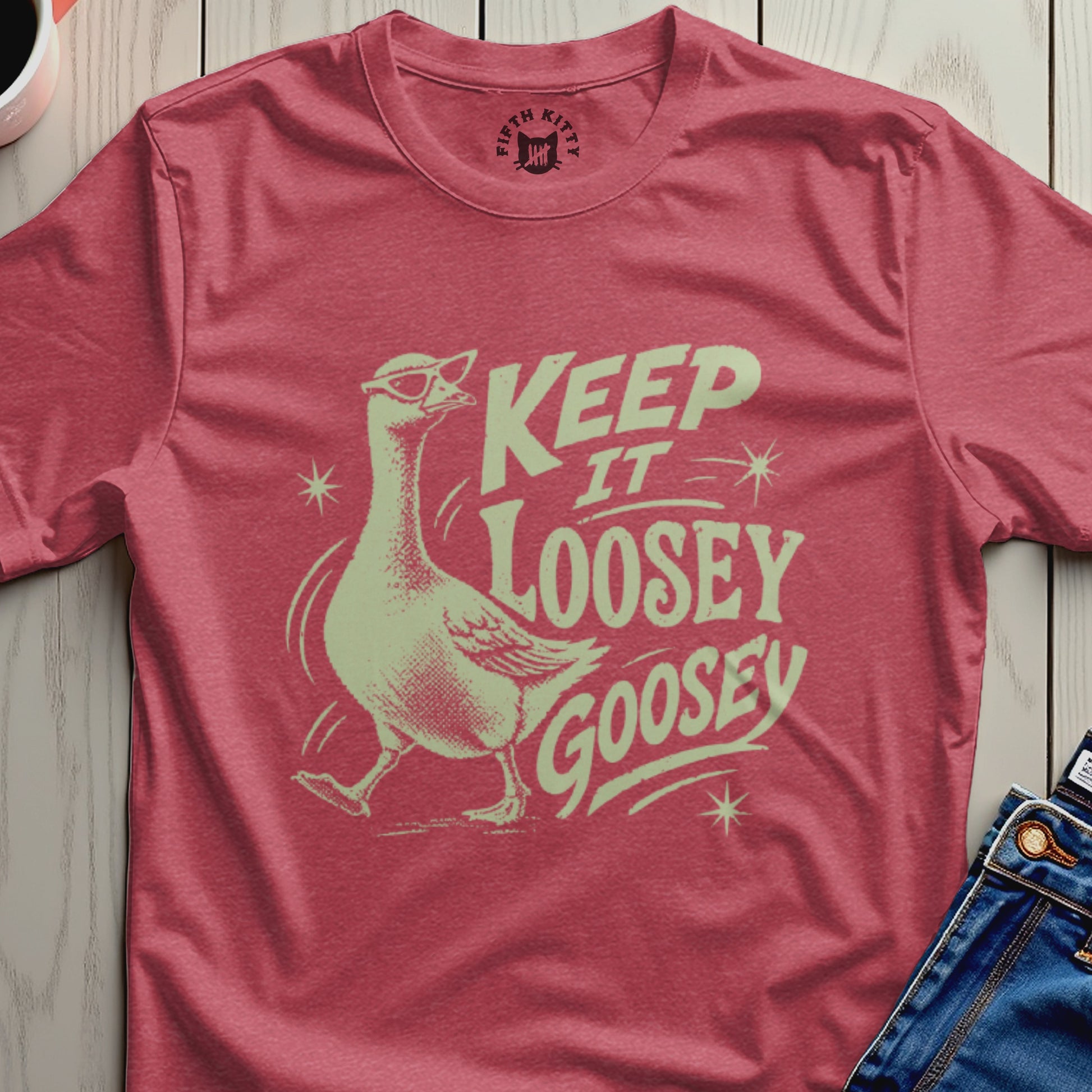 Pink t-shirt with a graphic of a goose wearing sunglasses and the text "Keep It Loosey Goosey".