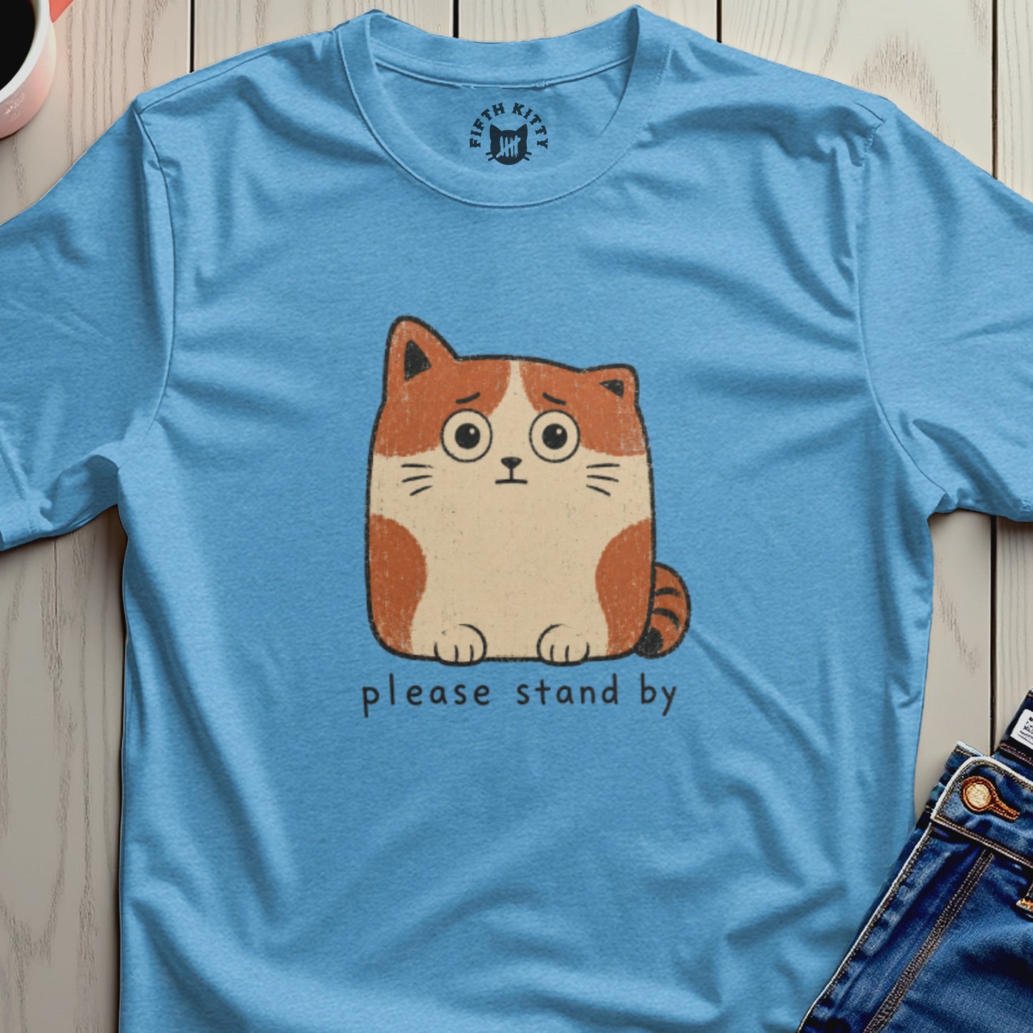 Light blue t-shirt with distressed animated cat graphic and "please stand by" text.