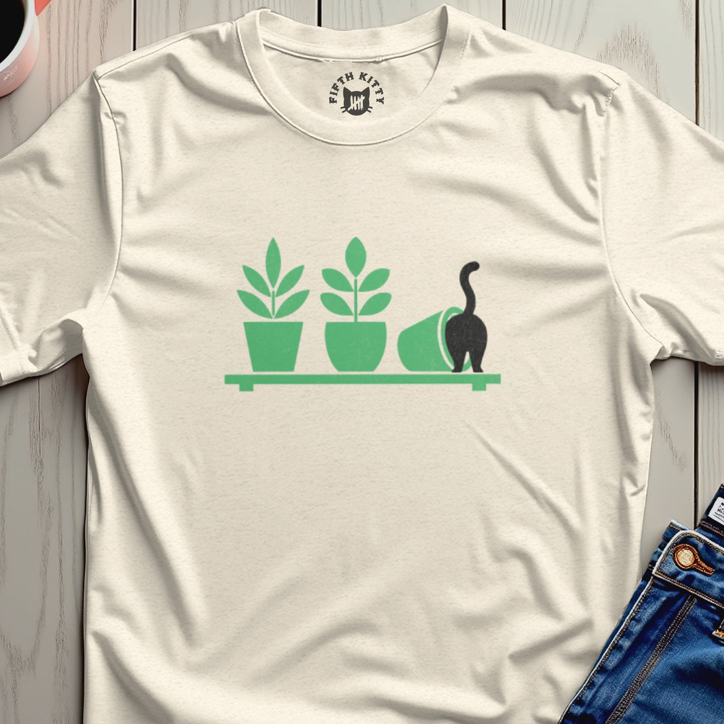 Cream t-shirt with green plant icons and a black cat knocking over a pot.