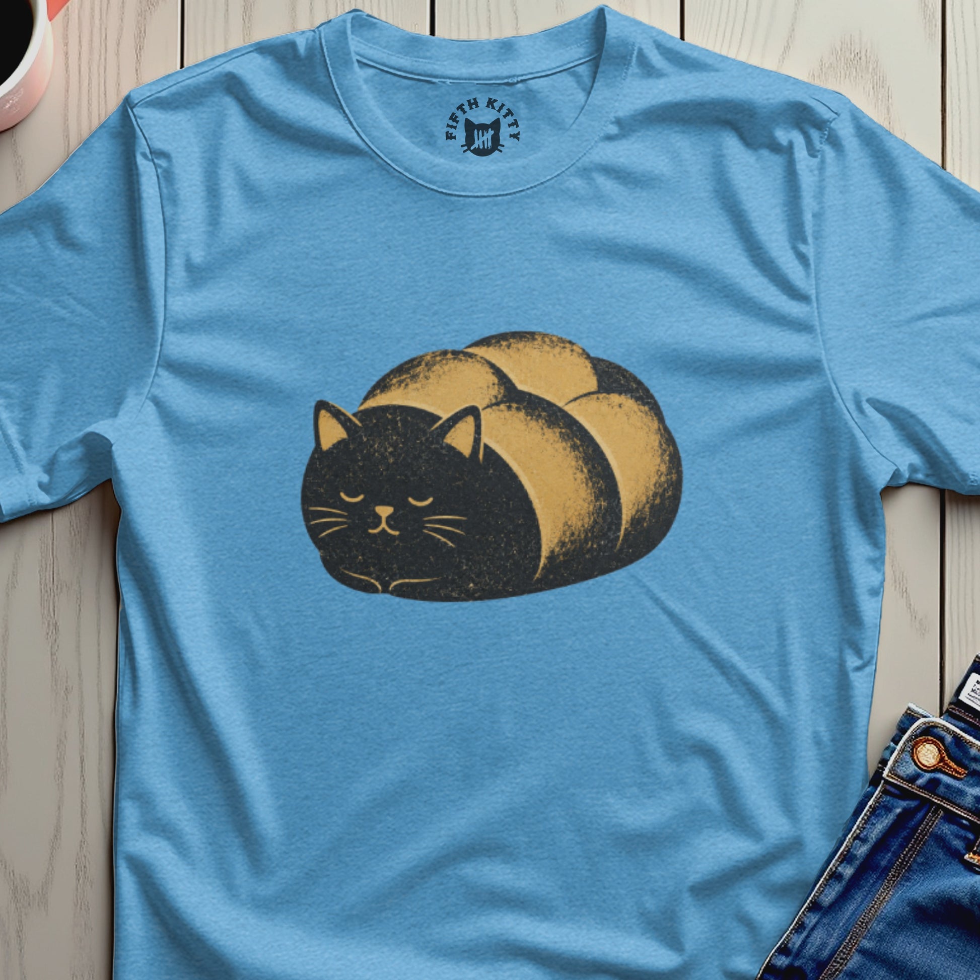 Light blue t-shirt with a cartoon loaf of bread shaped black cat graphic.