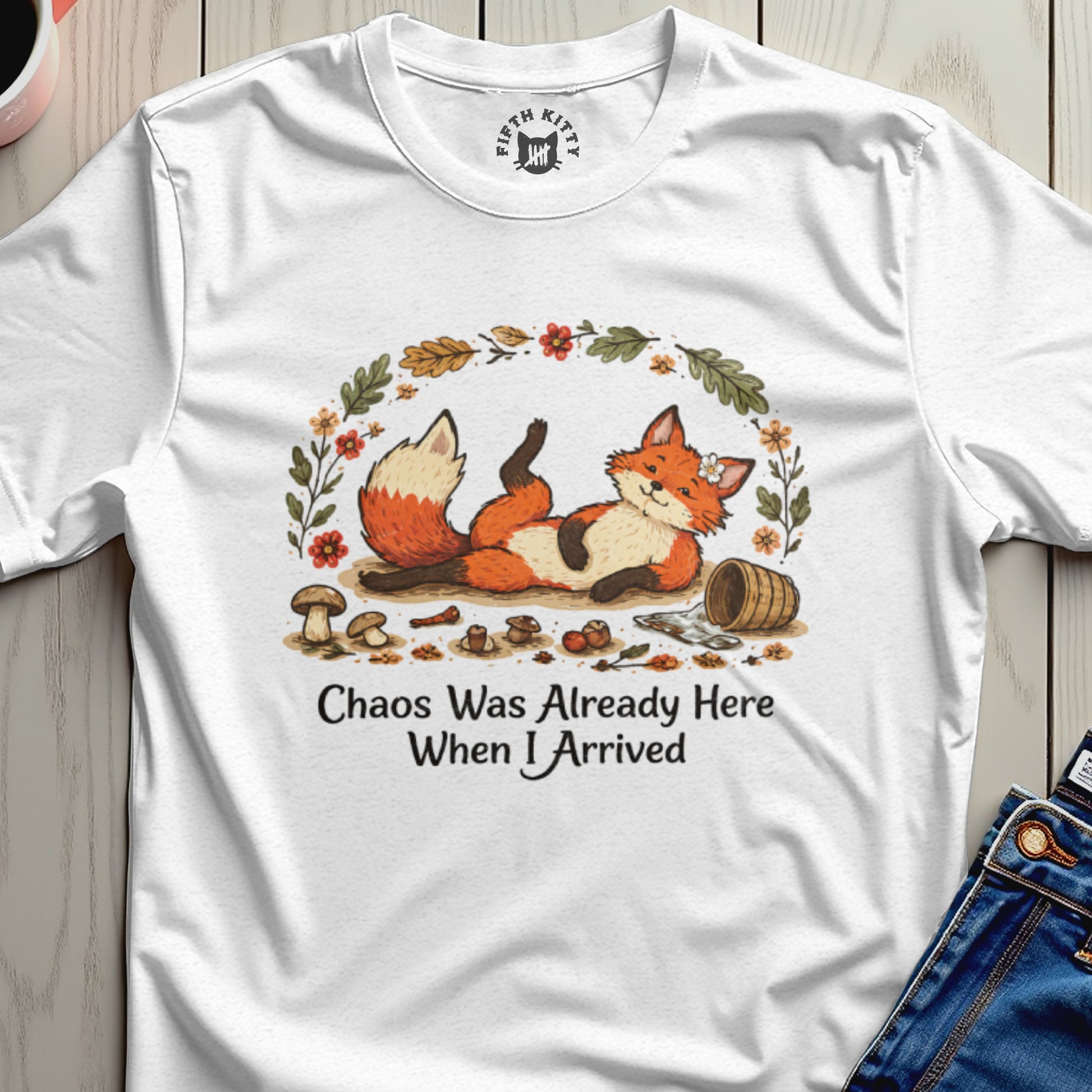 White t-shirt with a relaxed fox illustration and text "Chaos Was Already Here When I Arrived".