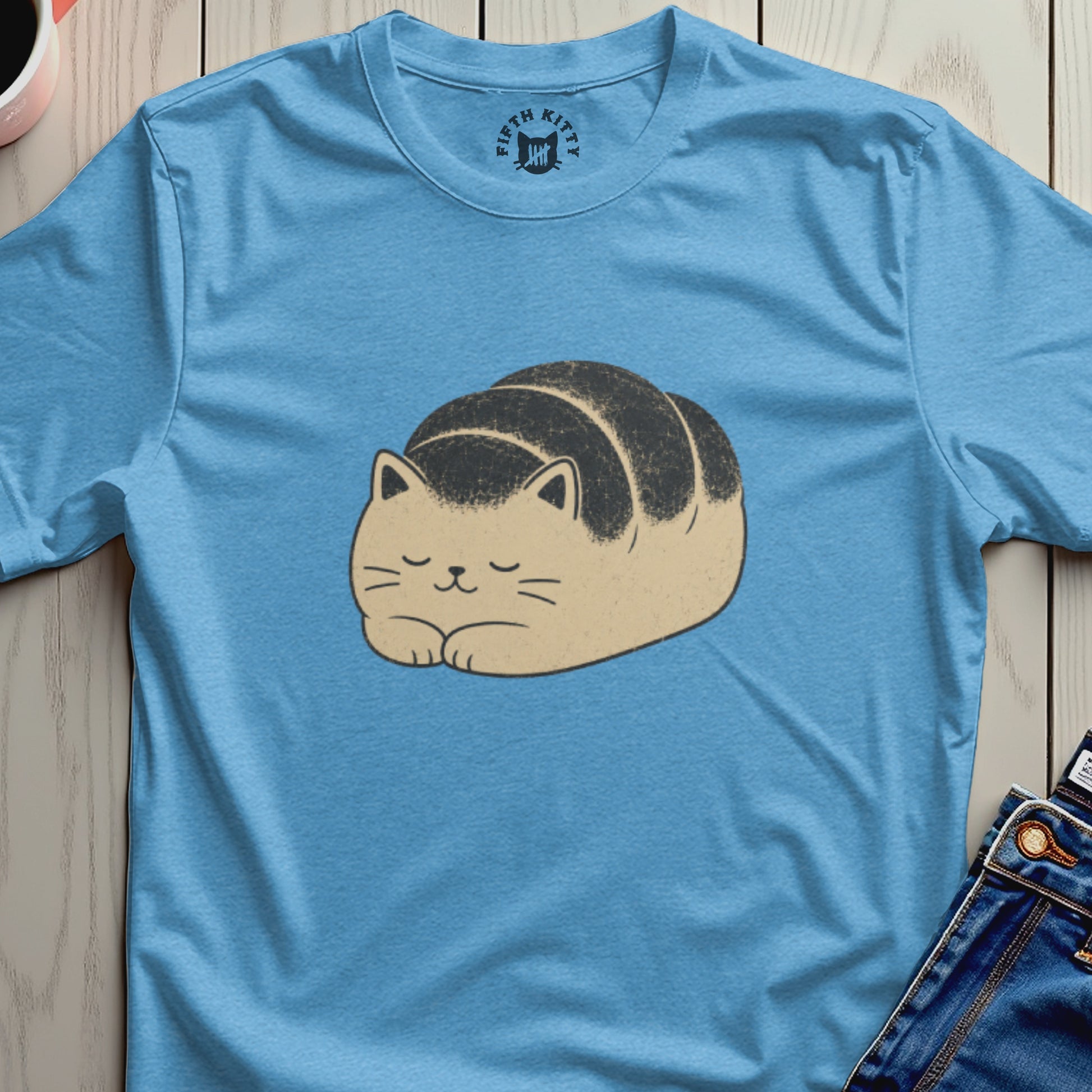 Light blue t-shirt featuring a cartoon cat shaped like a bread roll.