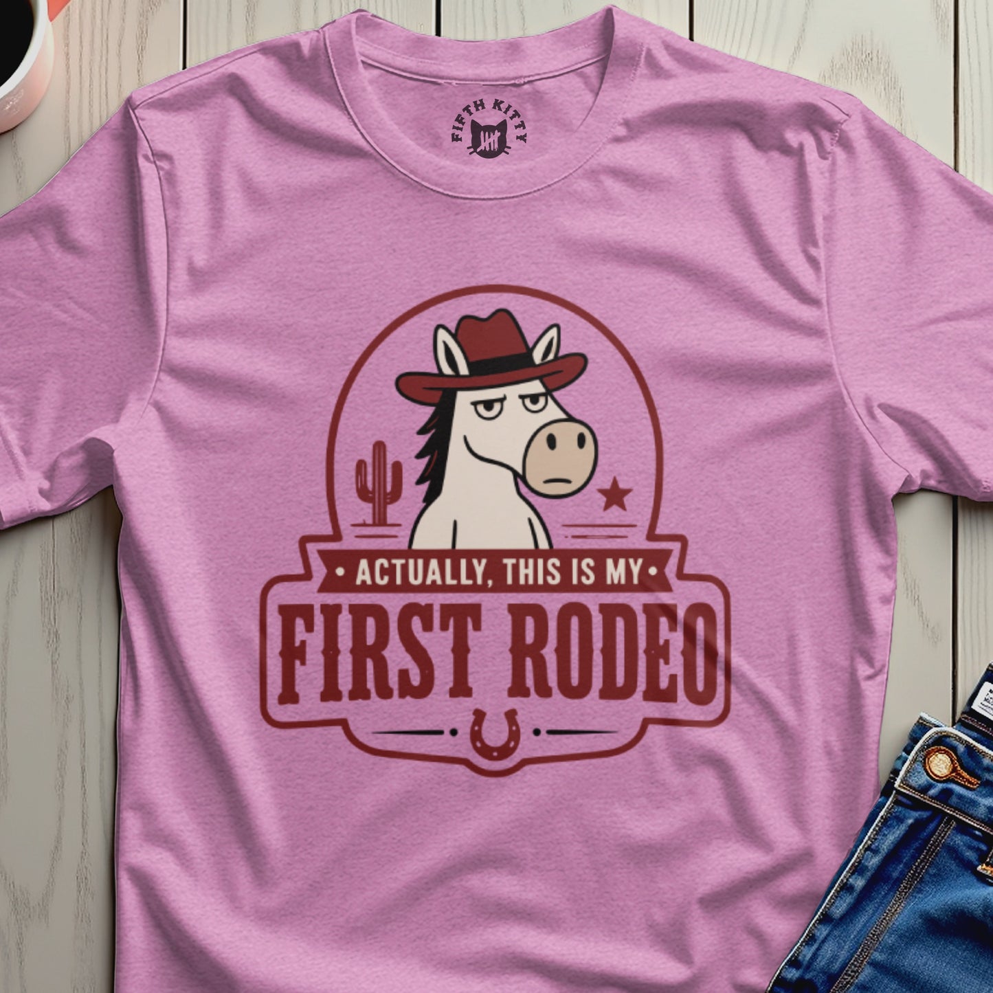 Pink t-shirt with a cartoon horse in a cowboy hat and text "Actually, This Is My First Rodeo".