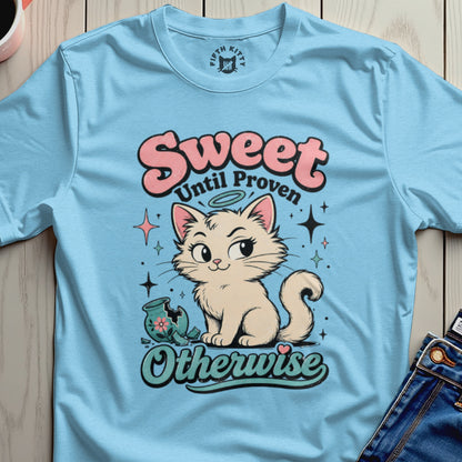 Light blue t-shirt with a cream cat sitting next to a broken vase, text reads "Sweet Until Proven Otherwise".