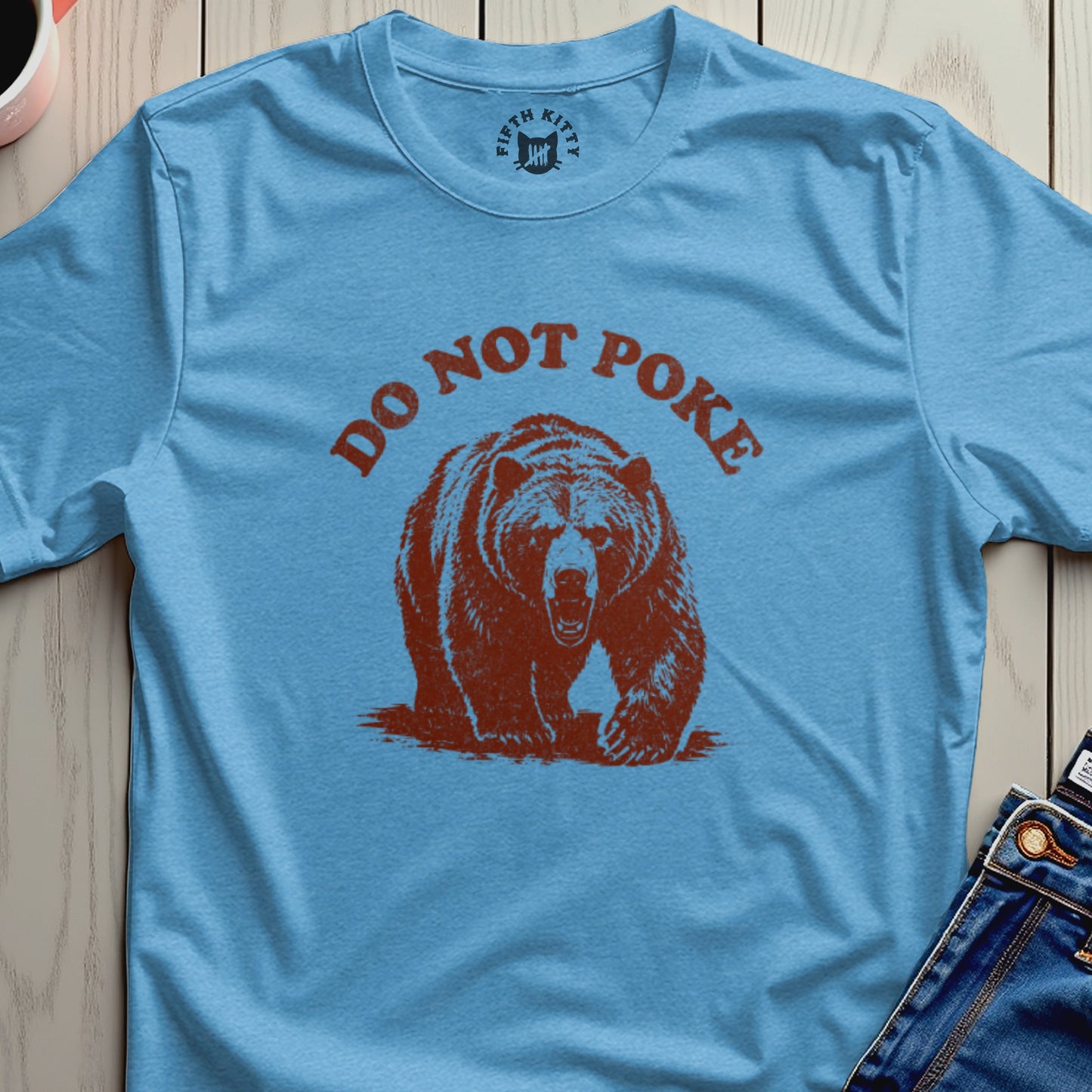 Light blue t-shirt with a brown bear and "DO NOT POKE" text.