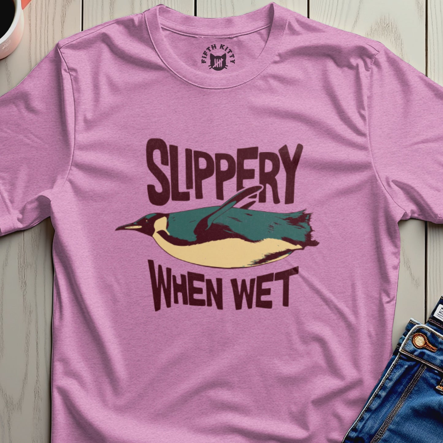 Pink t-shirt with a graphic of a penguin and text "SLIPPERY WHEN WET".