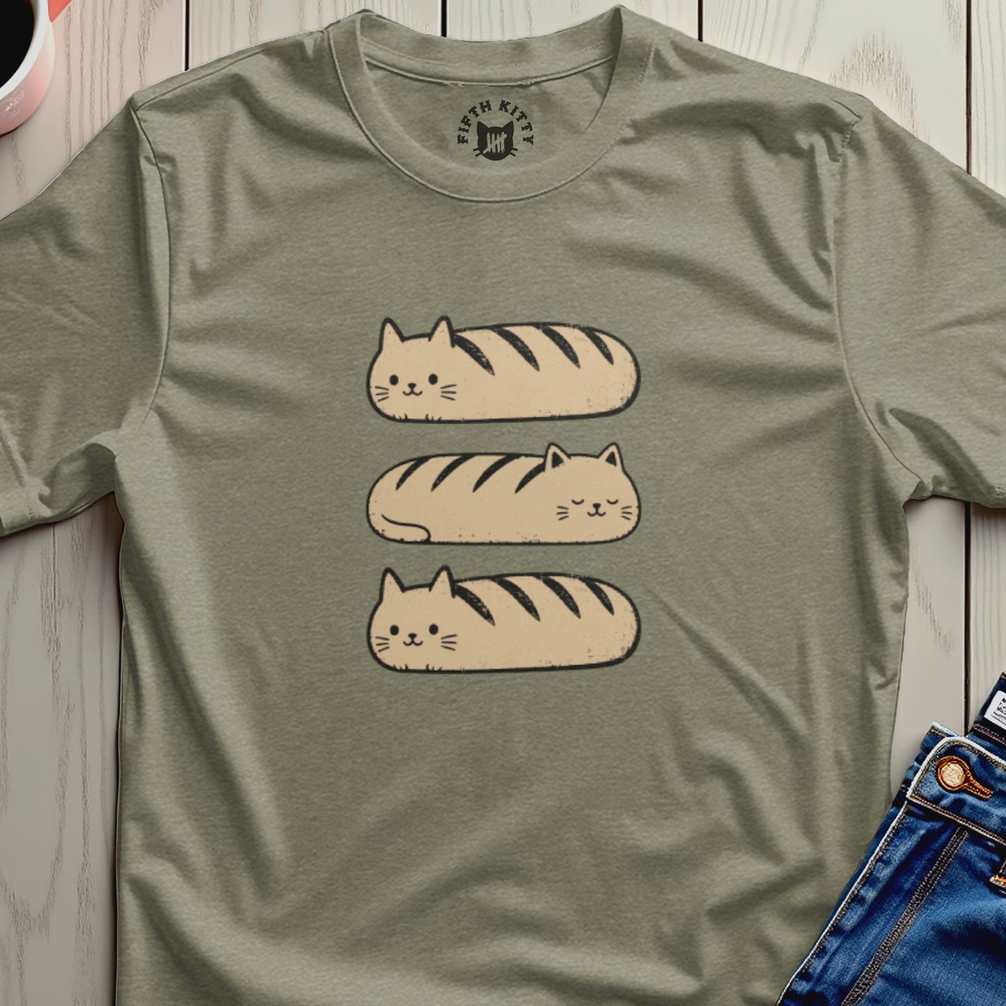 Three cat loaves stacked vertically on a tan t-shirt.