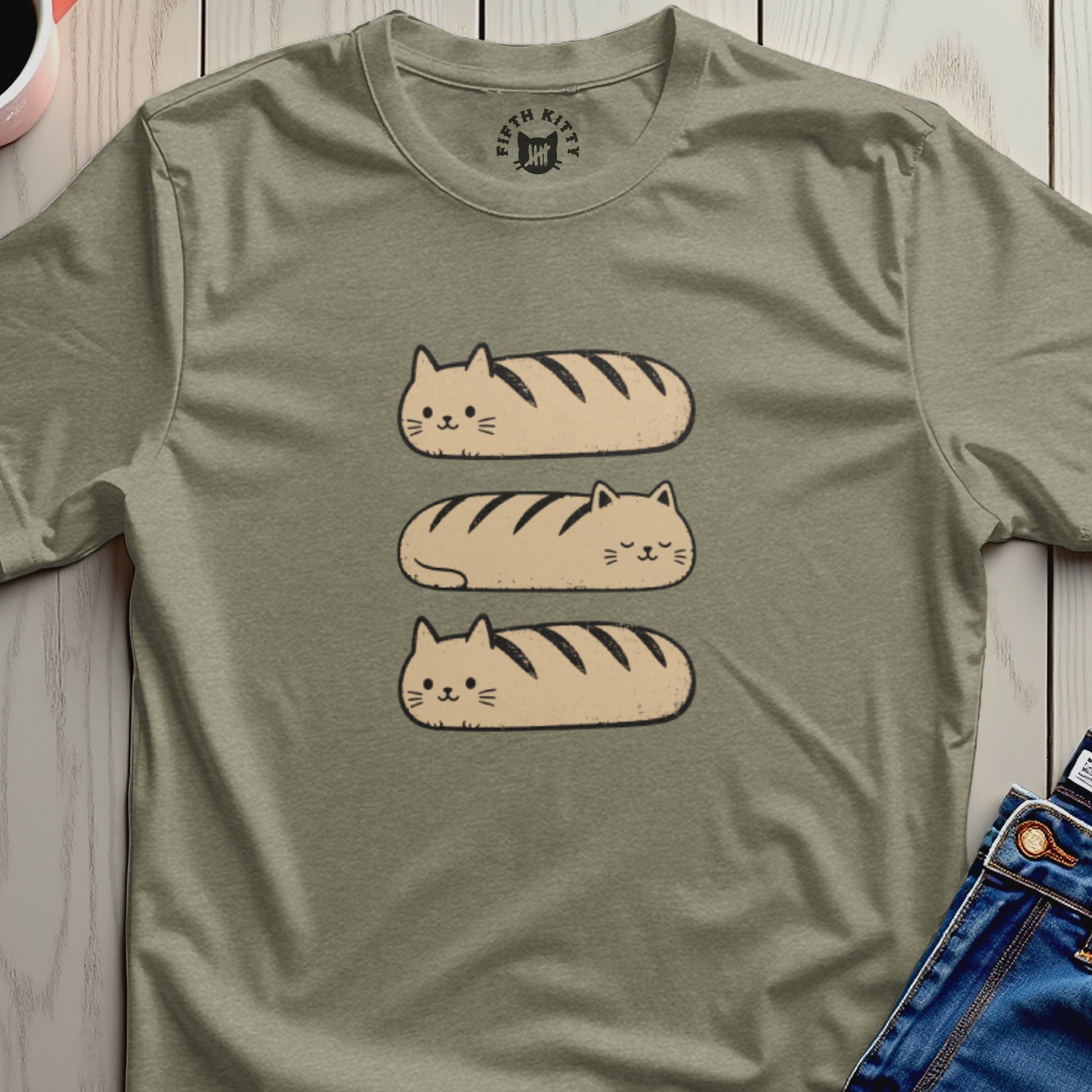 Three cat loaves stacked vertically on a tan t-shirt.