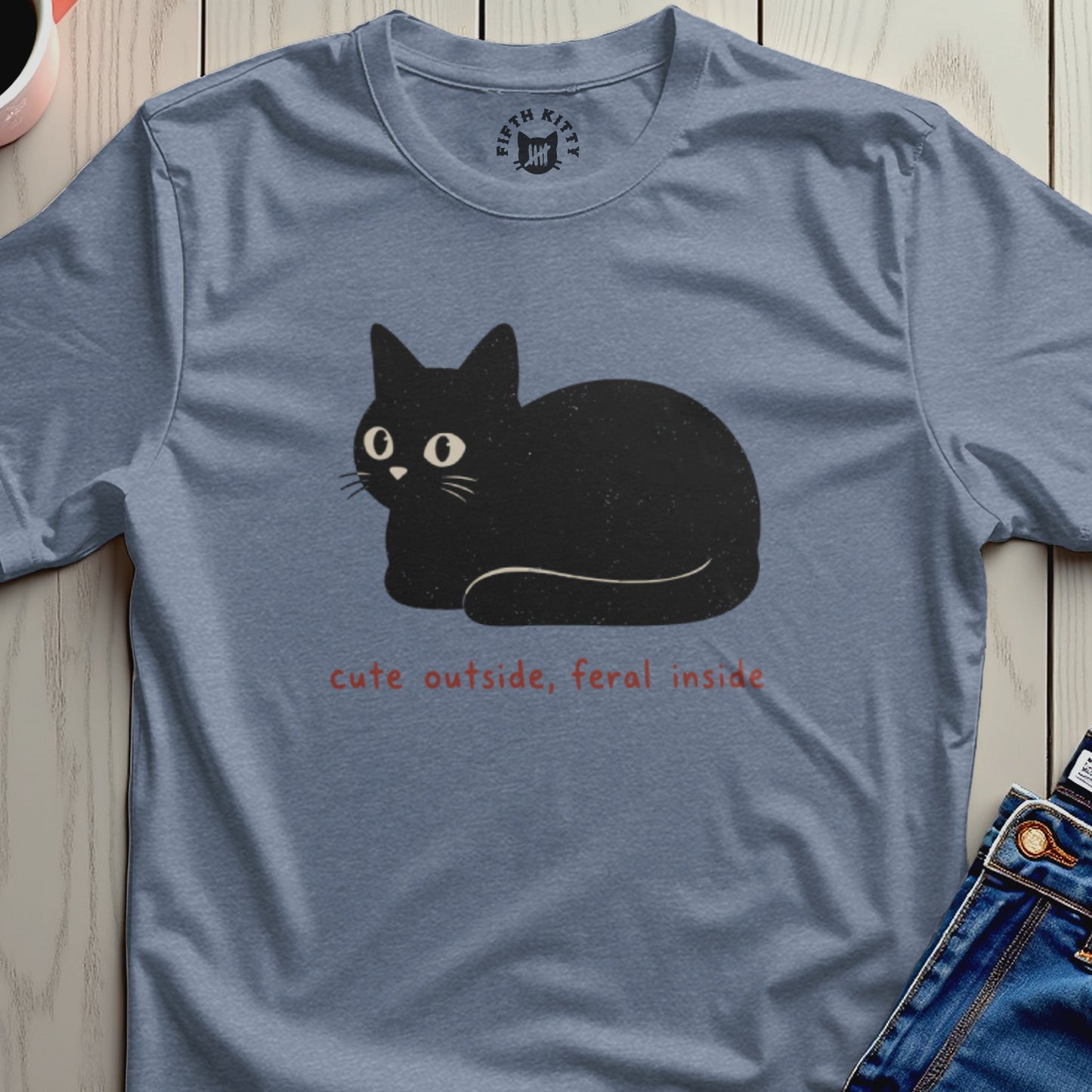 Blue t-shirt with a black cat graphic and text "cute outside, feral inside".