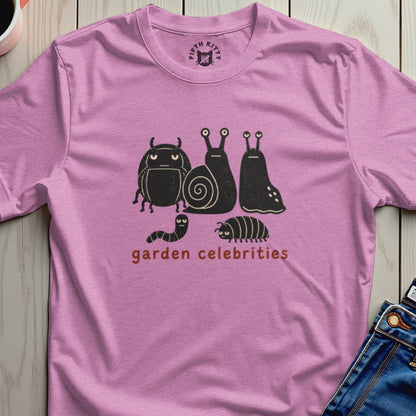 Pink t-shirt with a graphic of cartoon bugs and snails and the text "garden celebrities."