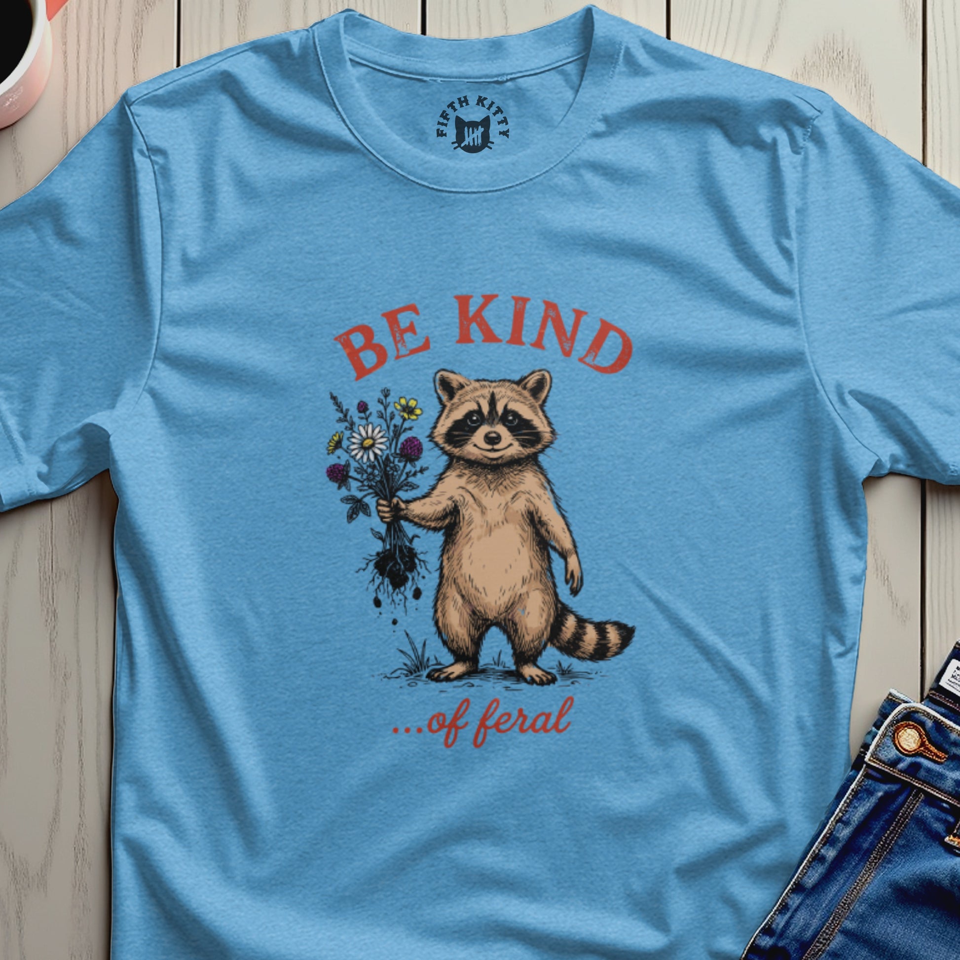 Raccoon holding bouquet of flowers with "Be Kind... of Feral" text.