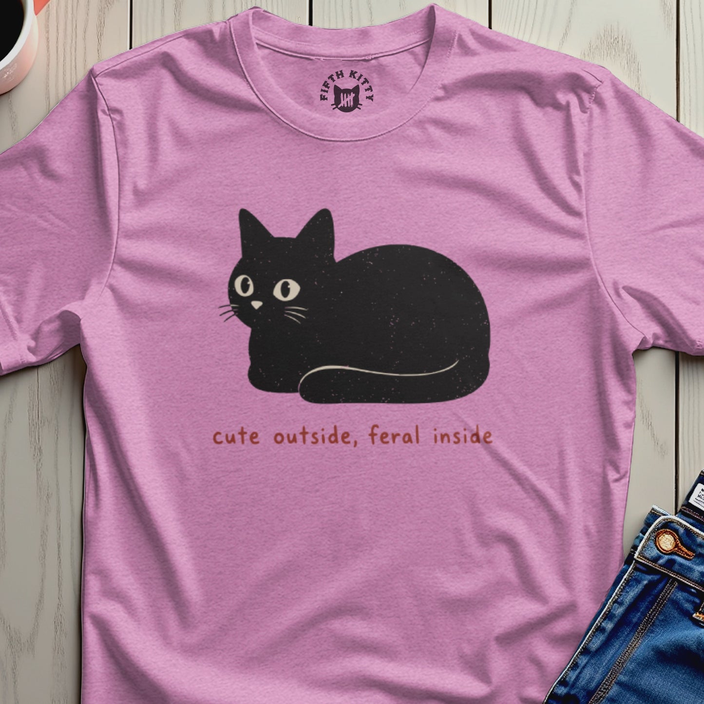 Pink t-shirt with a black cat graphic and text reading "cute outside, feral inside."