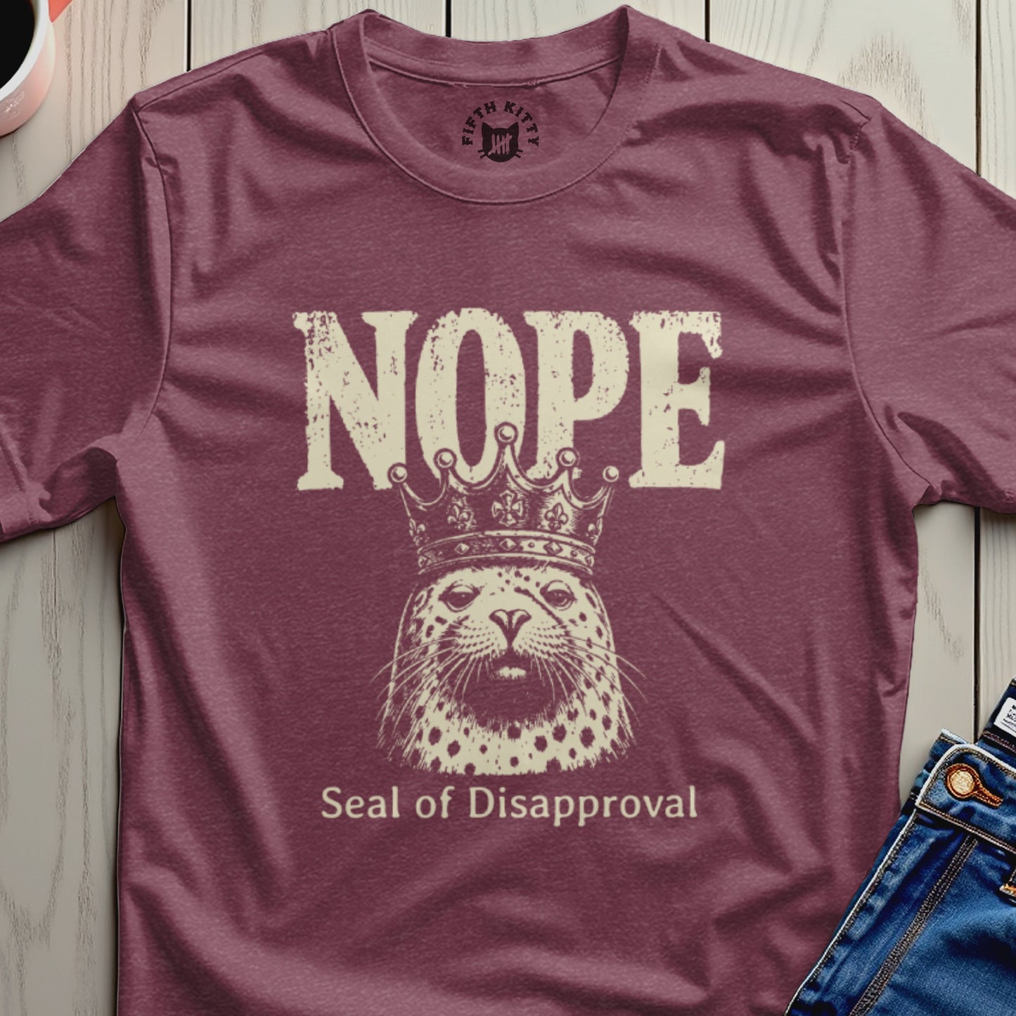 T-shirt with a seal wearing a crown and text "NOPE Seal of Disapproval".