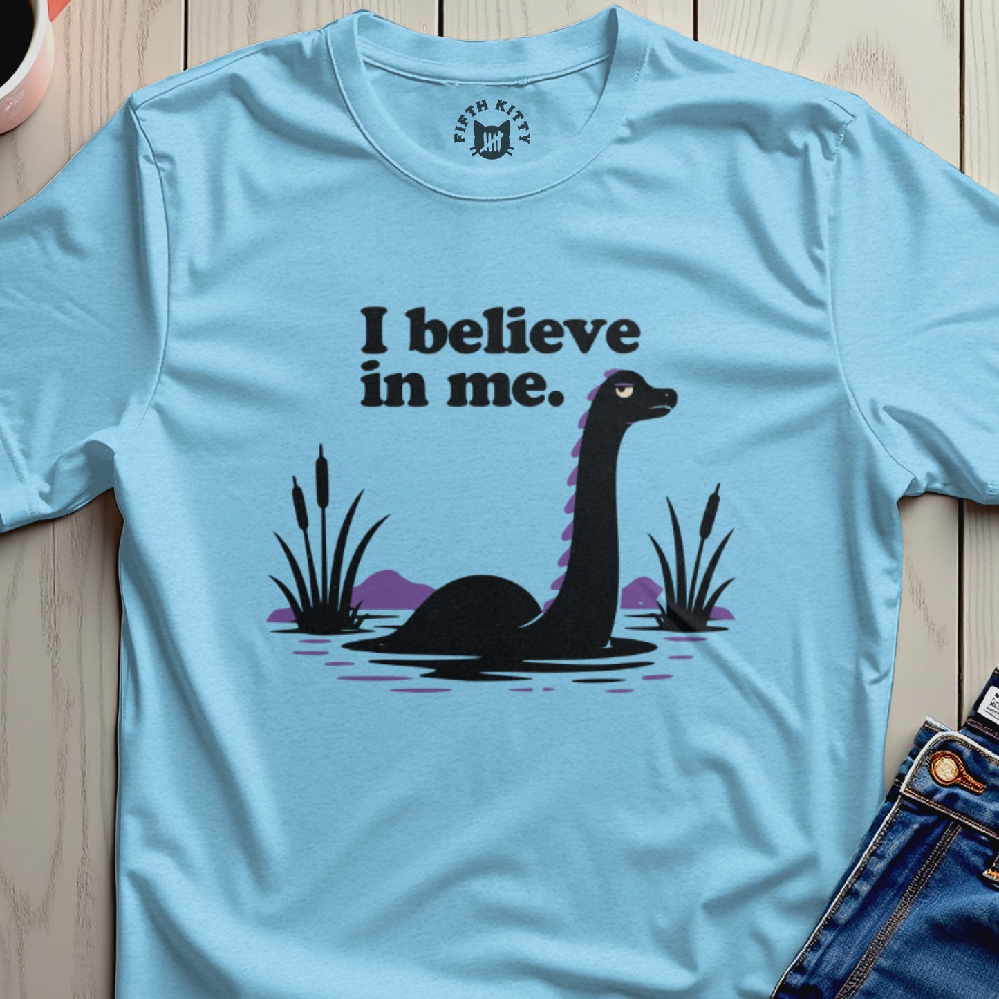 Light blue t-shirt with a Loch Ness Monster graphic and "I believe in me." text.