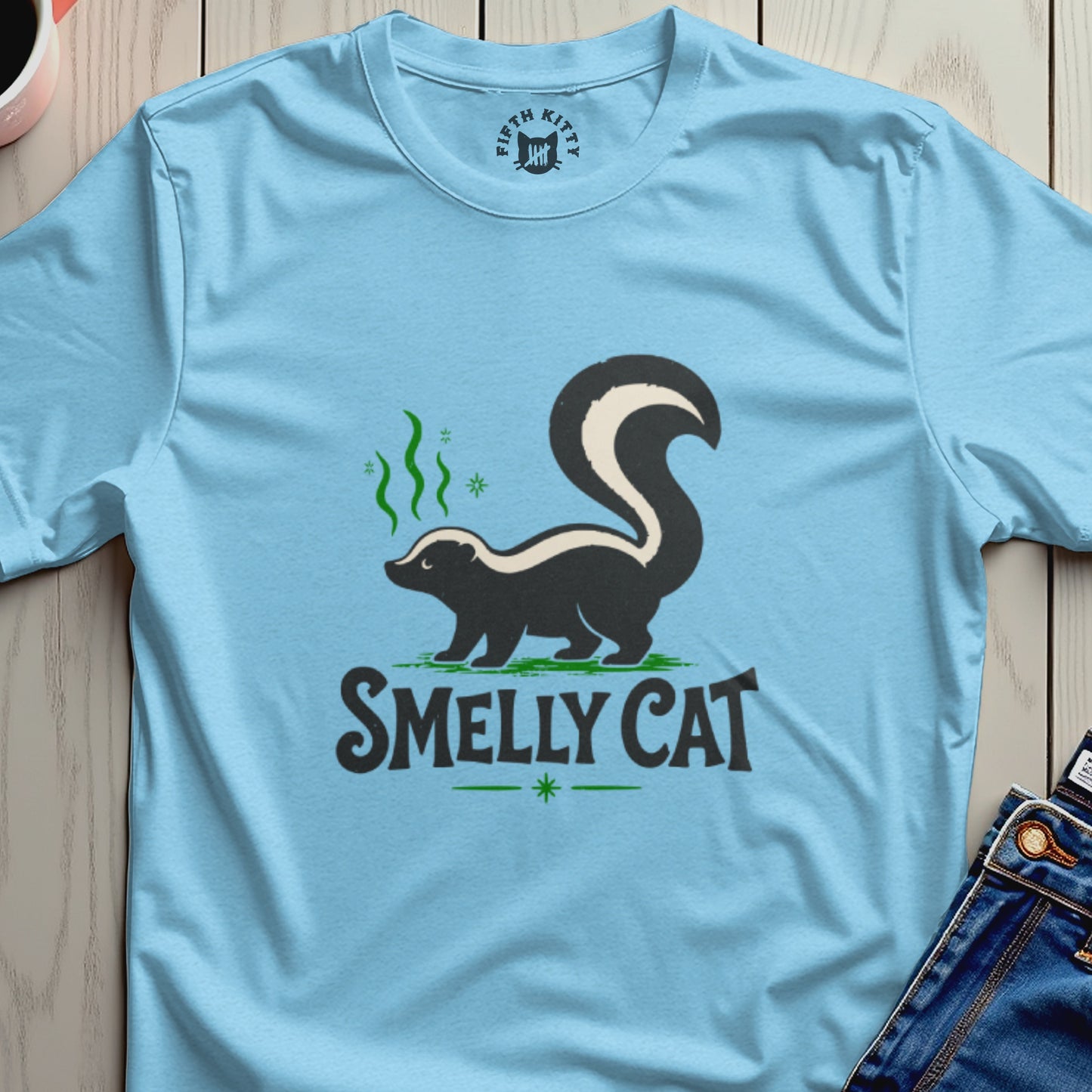 Light blue t-shirt with a skunk graphic and "SMELLY CAT" text.