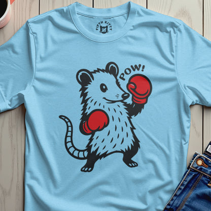 Light blue t-shirt with a cartoon opossum wearing boxing gloves and the word "POW!".